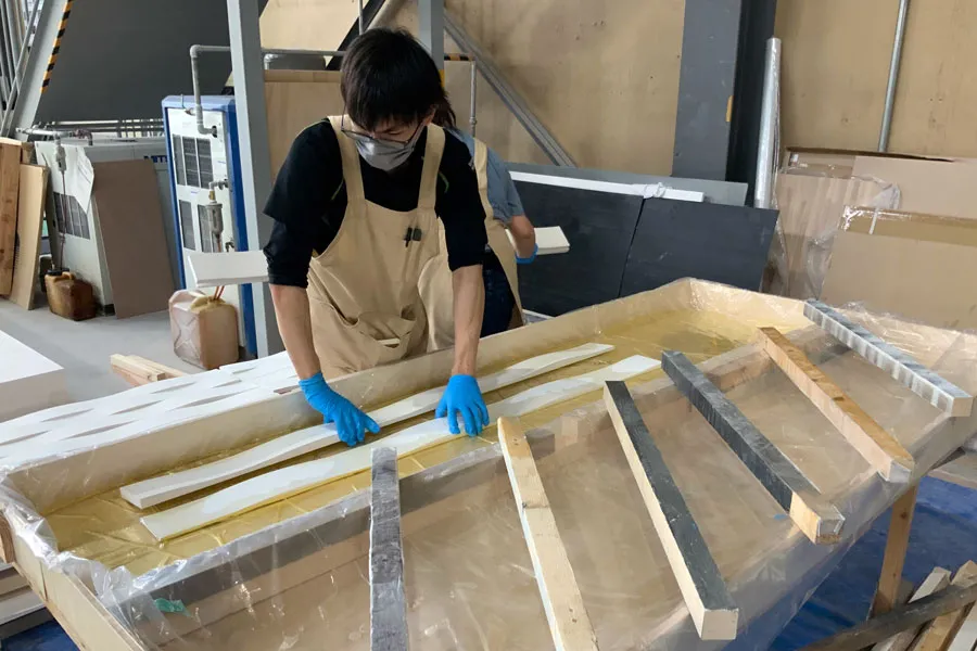 パネル塗装の準備作業。塗装前の準備工程を職人が細部まで行う様子