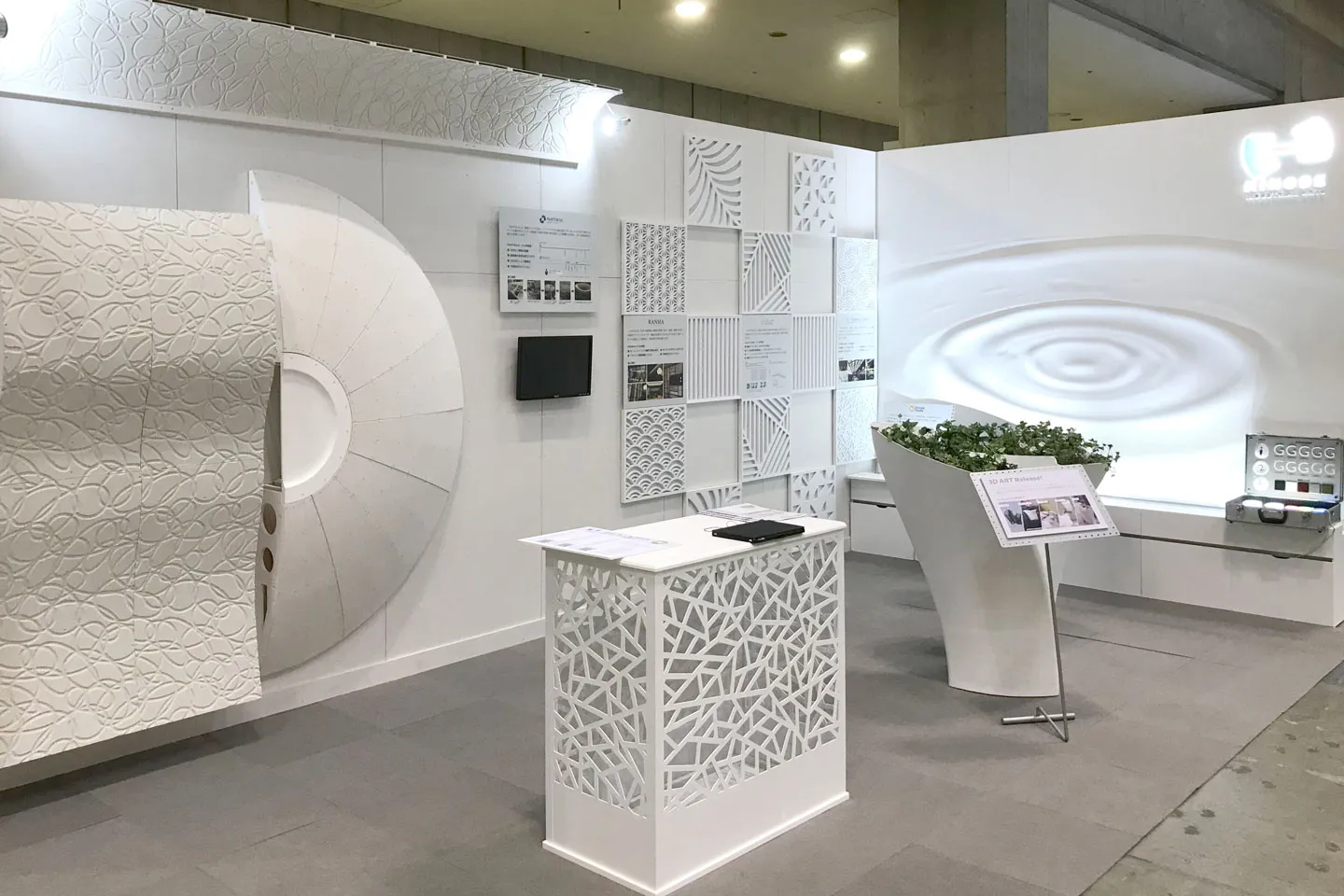 HINODEの展示ブース。純白の壁面に波紋や和柄をモチーフにした装飾パネルを配置し、デザインサンプルを展示