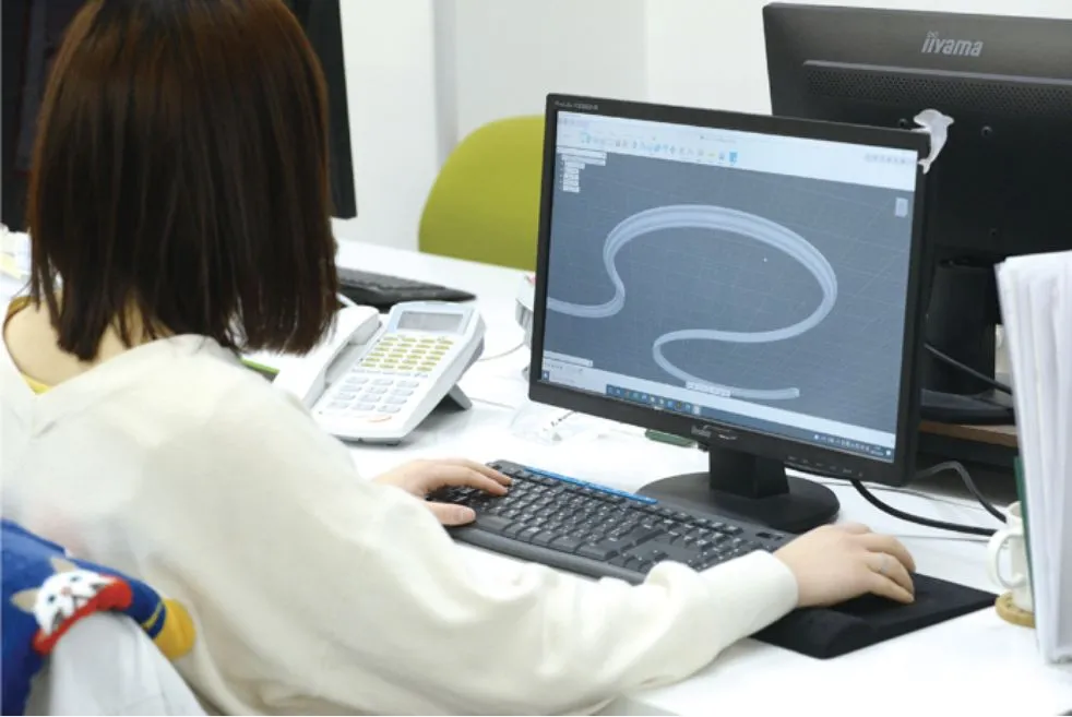 日の出工芸のデザイナーがCADソフトを使用して曲線的なデザインパネルの設計作業を行う様子