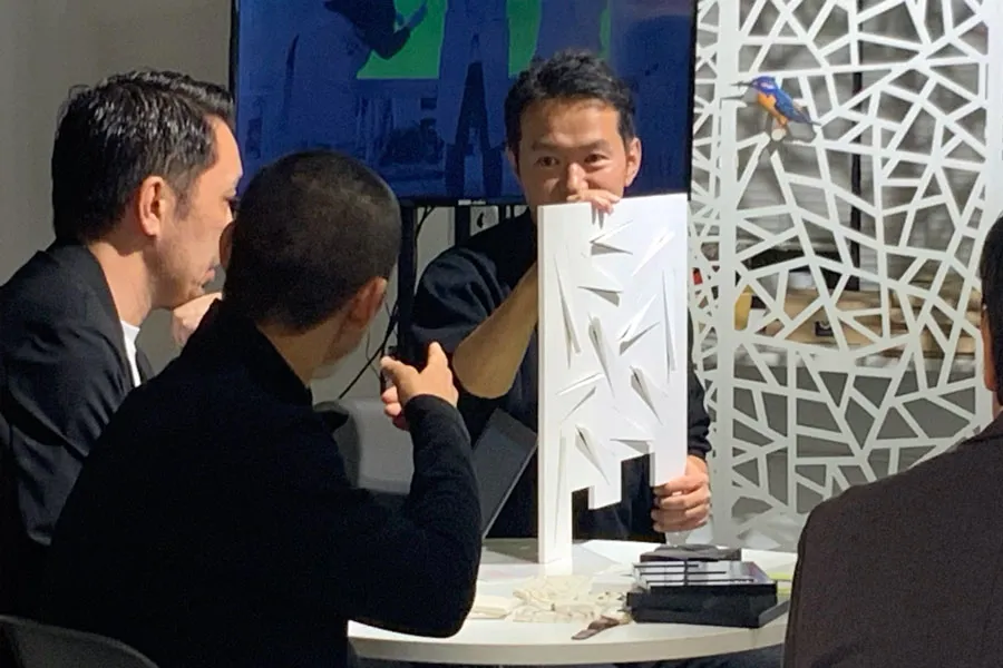 5D Wallの開発コンセプトを説明するプレゼンテーション。デザイナーが製品サンプルを手に取りながら具体的な特徴を解説